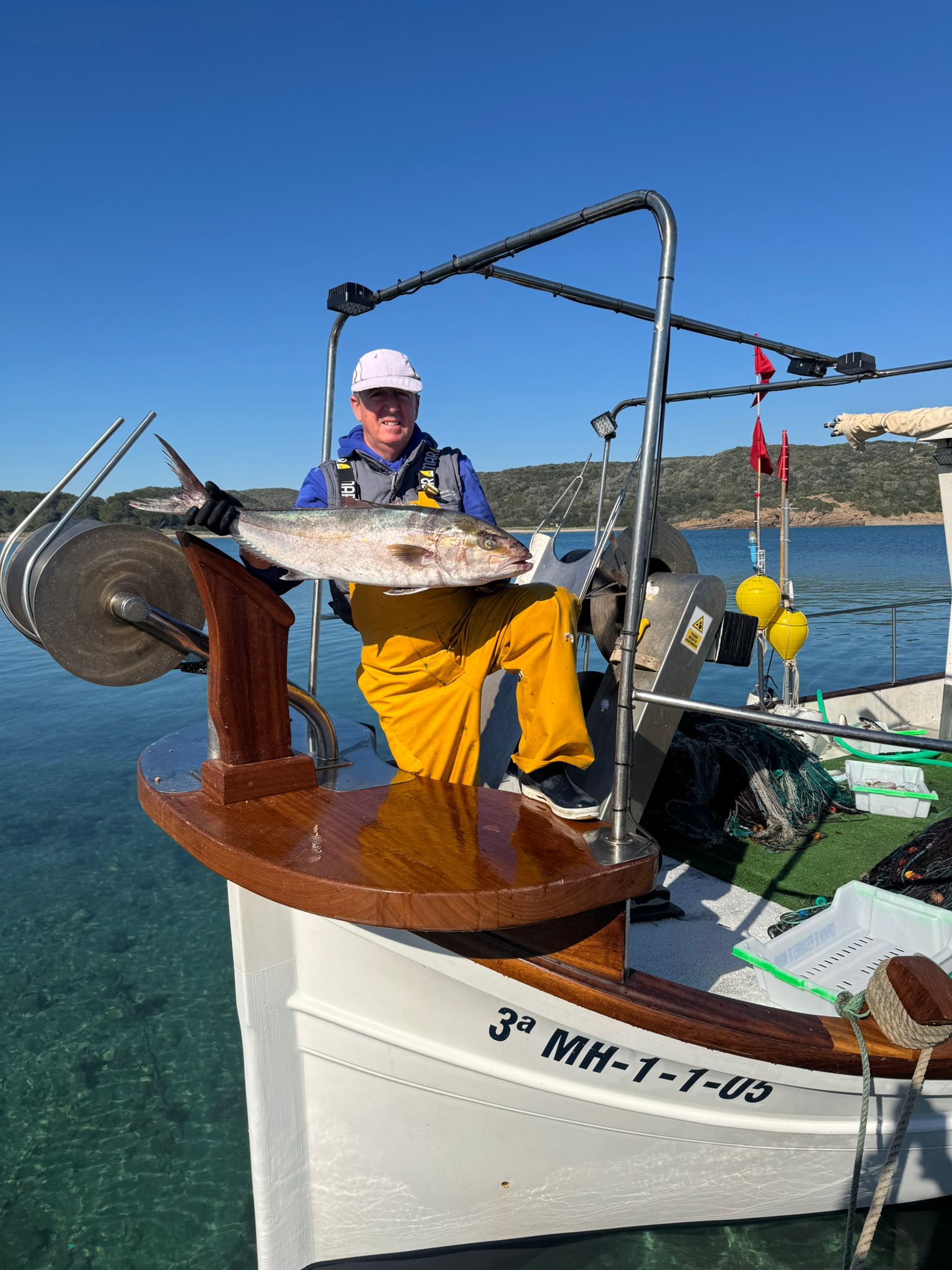Pescador artesanal con su captura en la barca de Menorca